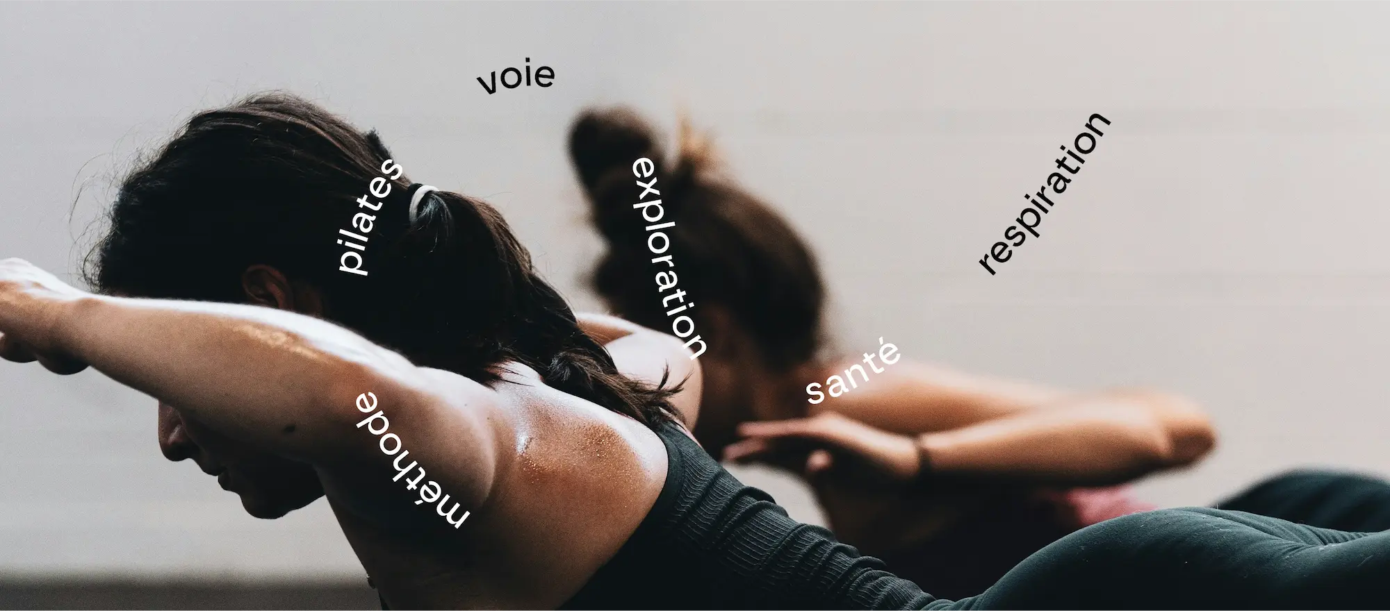 Jeunes femmes pratiquant le gainage dans le cadre d'un cours de pilates